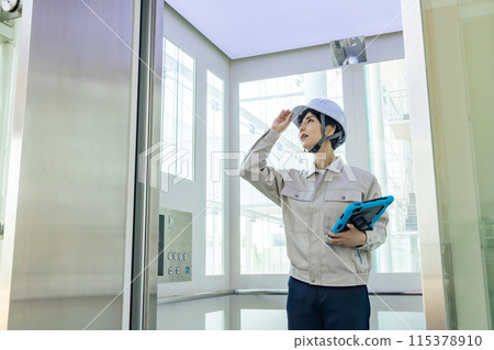 Worker inspecting an elevator 115378910