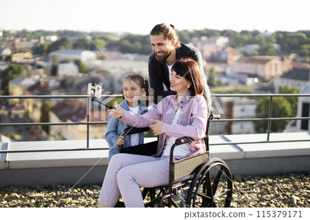 Mother in wheelchair surrounded by care from loving daughter and husband. Mother in wheelchair surrounded by care from loving daughter and husband. 115379171
