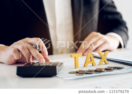Businessman's hands calculating numbers at a calculator.Tax deduction planning concept. 115379270