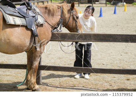 Woman interacting with horses Woman interacting with horses 115379952