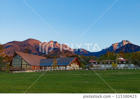 View of the Yatsugatake mountain range bathed in the morning sun from the Kiyosato Plateau in the early morning, spring 115380423