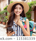 A young woman wearing a hat and carrying a smartphone and a backpack on a trip 115381339