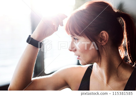 Headshot of beautiful redhead woman during fitness routine. Home workout on gym mt in living room, sporty woman wearing sportswear. 115381585
