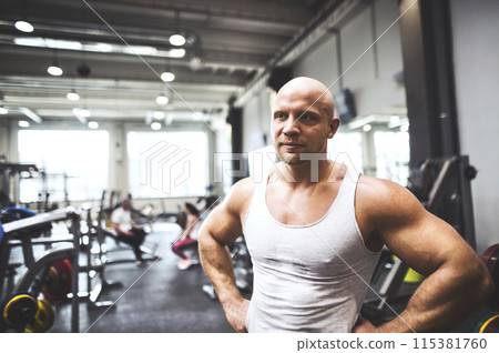 Strong man exercising in gym. Routine workout for physical and mental health. Strong man exercising in gym. Routine workout for physical and mental health. 115381760