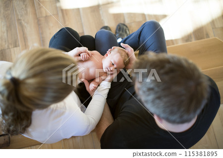 New parents holding newborn baby girl. Unconditional paternal love, idyllic family moment. 115381895