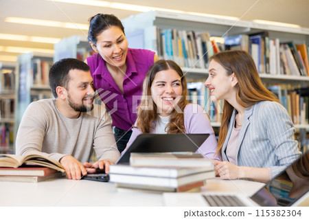 Group of friendly students working on joint research in library Group of friendly students working on joint research in library 115382304