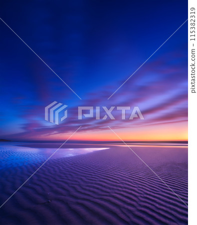 Seascape during sunrise. Long exposure. Lines of sand on the seashore. Seascape during sunrise. Long exposure. Lines of sand on the seashore. 115382319