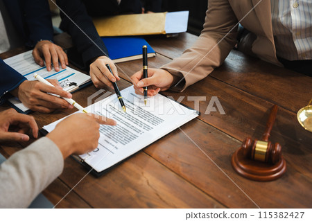 Lawyer signing important legal document on desk at office. Lawyer signing important legal document on desk at office. 115382427
