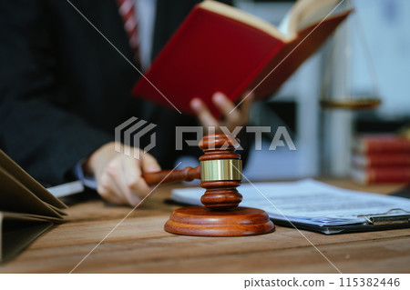 Serious pensive lawyer working at desk in office. Serious pensive lawyer working at desk in office. 115382446