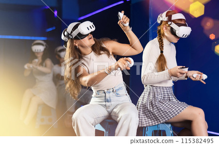 Female friends competing in two-on-two virtual reality game 115382495