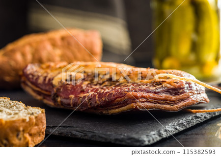 Smoked and Cured Pork Belly With Caraway Seeds on Cutting Board. 115382593