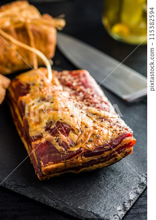 Smoked and Cured Pork Belly With Caraway Seeds on Cutting Board. 115382594