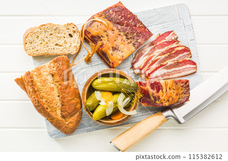 Closeup of Sliced Smoked Bacon on white Cutting Board. Top view. 115382612