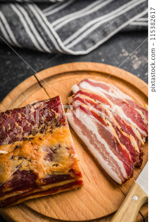 Closeup of Sliced Smoked Bacon on wooden Cutting Board Closeup of Sliced Smoked Bacon on wooden Cutting Board 115382617