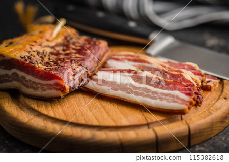 Closeup of Sliced Smoked Bacon on wooden Cutting Board Closeup of Sliced Smoked Bacon on wooden Cutting Board 115382618