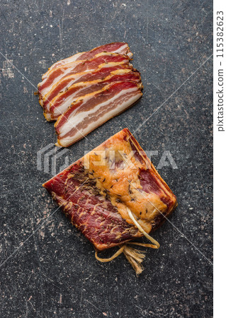 Closeup of Sliced Smoked Bacon on black table. Top view. 115382623