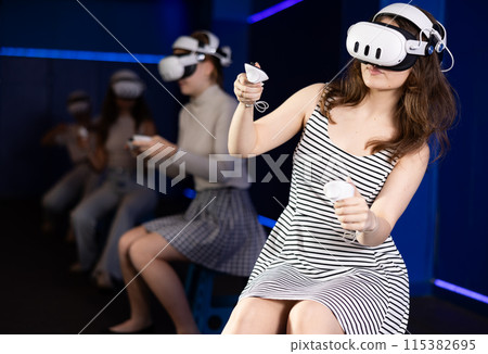 Expressive girl in VR goggles having fun in virtual reality room 115382695