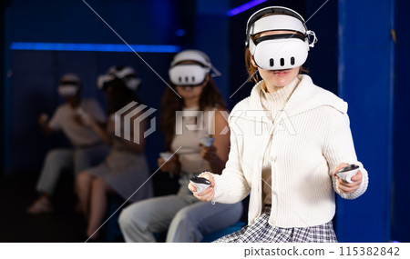 Girls using virtual reality glasses - girlfriends having fun with vr headset Girls using virtual reality glasses - girlfriends having fun with vr headset 115382842