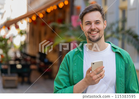 Man using smartphone typing text messages browsing internet, finishing work, looking at camera Man using smartphone typing text messages browsing internet, finishing work, looking at camera 115383595