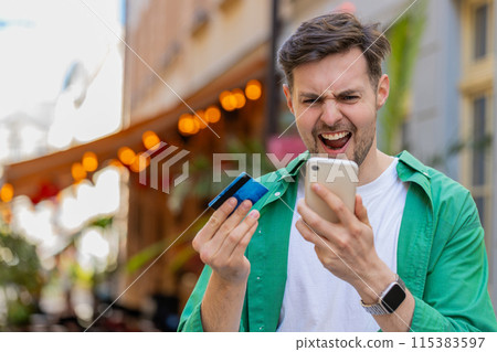 Shocked angry man trying to pay online shopping with smartphone blocked credit card lack of money 115383597