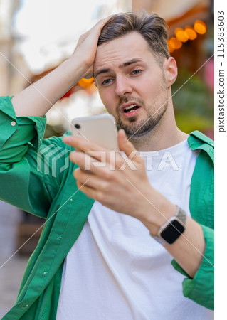Sad man using smartphone browsing loses lottery casino application results bad news fail virus Sad man using smartphone browsing loses lottery casino application results bad news fail virus 115383603