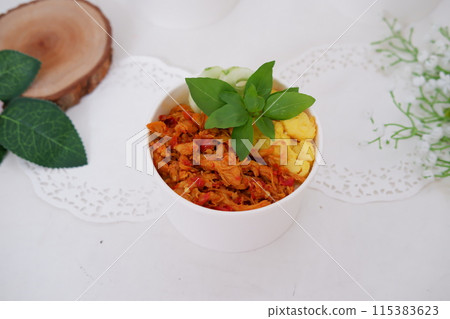 rice with sliced spicy chicken and vegetables as a background 115383623