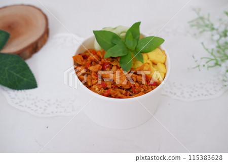 rice with sliced spicy chicken and vegetables as a background 115383628