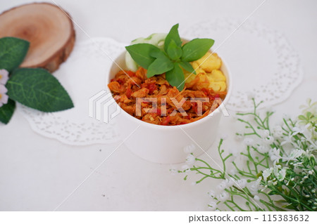 rice with sliced spicy chicken and vegetables as a background 115383632