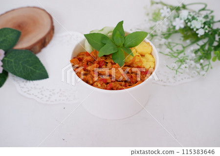 rice with sliced spicy chicken and vegetables as a background 115383646