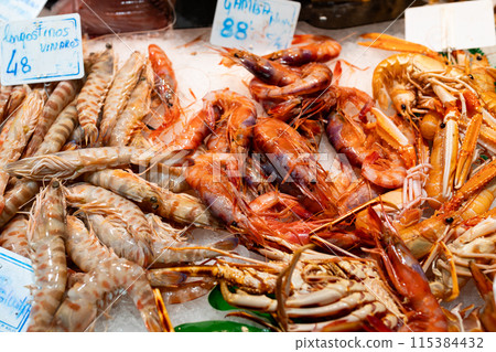 Tasty yummy Fresh organic tiger shrimps or prawns on ice background. 115384432