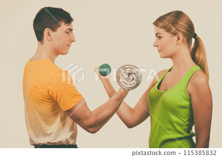 Couple exercising with dumbbells lifting weights 115385832