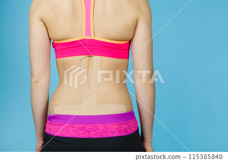 Woman with medical kinesio taping on back Woman with medical kinesio taping on back 115385840