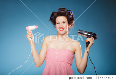 girl with curlers in hair holds hairdreyers girl with curlers in hair holds hairdreyers 115386307