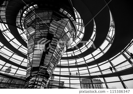 Inside view of the Reichstag glass dome in Berlin showing the mirrored central column and steel framework. Black and white image. Inside view of the Reichstag glass dome in Berlin showing the mirrored central column and steel framework. Black and white image. 115386347