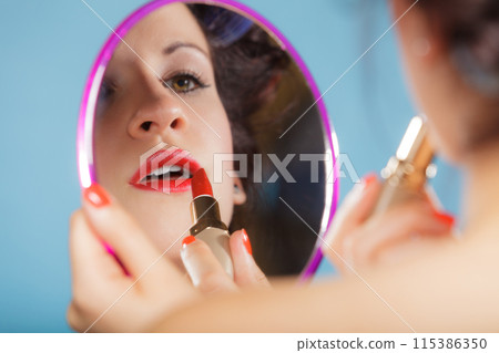 Woman applying red lipstick Woman applying red lipstick 115386350