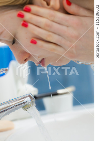 Woman washing face in bathroom. Hygiene. Woman washing face in bathroom. Hygiene. 115386632