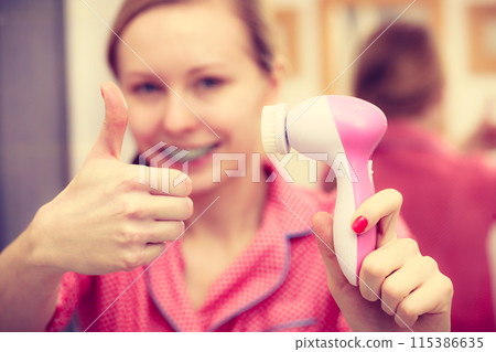 Woman holding facial cleansing brush Woman holding facial cleansing brush 115386635