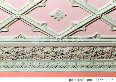Ceiling design elements. Light green gypsum bas-relief over pink background 115387027