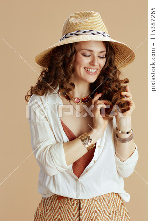 smiling stylish woman in blouse and shorts on beige smiling stylish woman in blouse and shorts on beige 115387265