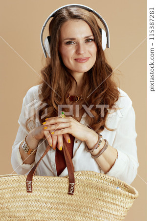 smiling housewife in blouse and shorts on beige 115387281