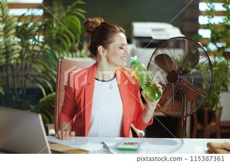 happy modern woman worker in modern green office in red jacket happy modern woman worker in modern green office in red jacket 115387361