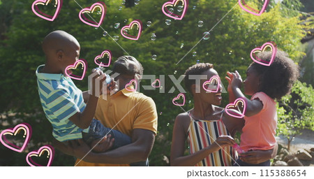 Image of hearts over happy african american family making soap bubbles in garden Image of hearts over happy african american family making soap bubbles in garden 115388654