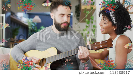 Image of flowers over happy diverse couple playing guitar together 115388917