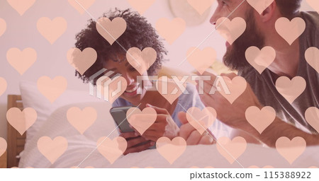 Image of hearts over happy diverse couple using smartphone Image of hearts over happy diverse couple using smartphone 115388922