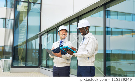 A group of multinational engineers having a conversation in front of a building A group of multinational engineers having a conversation in front of a building 115389249