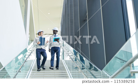 Group of multinational engineers having a conversation in a building Group of multinational engineers having a conversation in a building 115389258