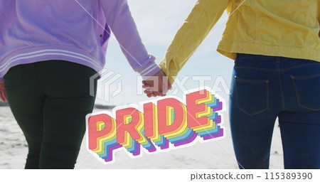 Image of pride over hands of lesbian couple walking on beach Image of pride over hands of lesbian couple walking on beach 115389390