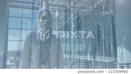 Image of financial graphs over biracial businesswoman in hijab walking in office 115389460