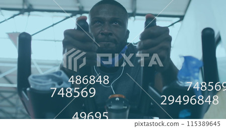 Image of symbols changing over man with face mask exercising on elliptical bike in gym 115389645