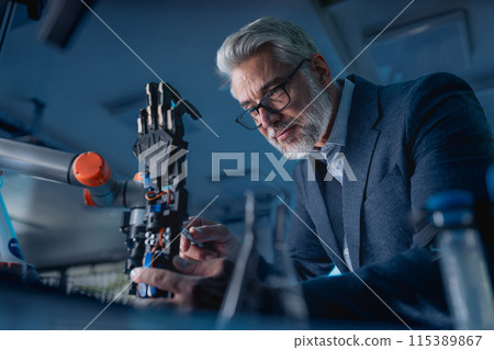 Robotics engineer adjusting, calibring robotic prosthetic hand. Concept of modern technology in medicine. Robotic prosthetics, biomechatronics and neuroscience. 115389867